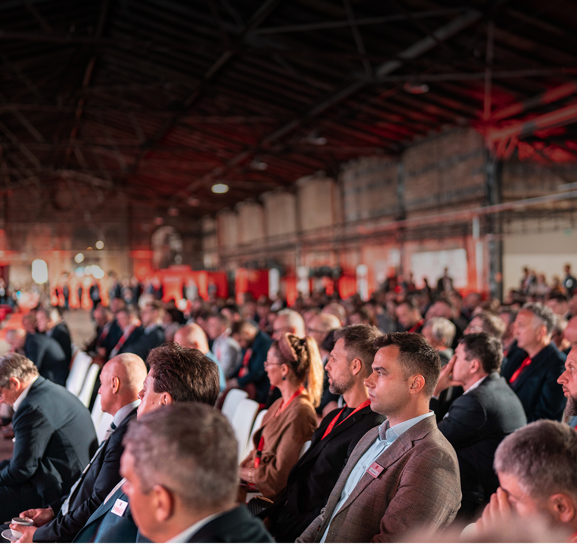 Publiczność na sali konferencyjnej, widok w poprzek rzędów.